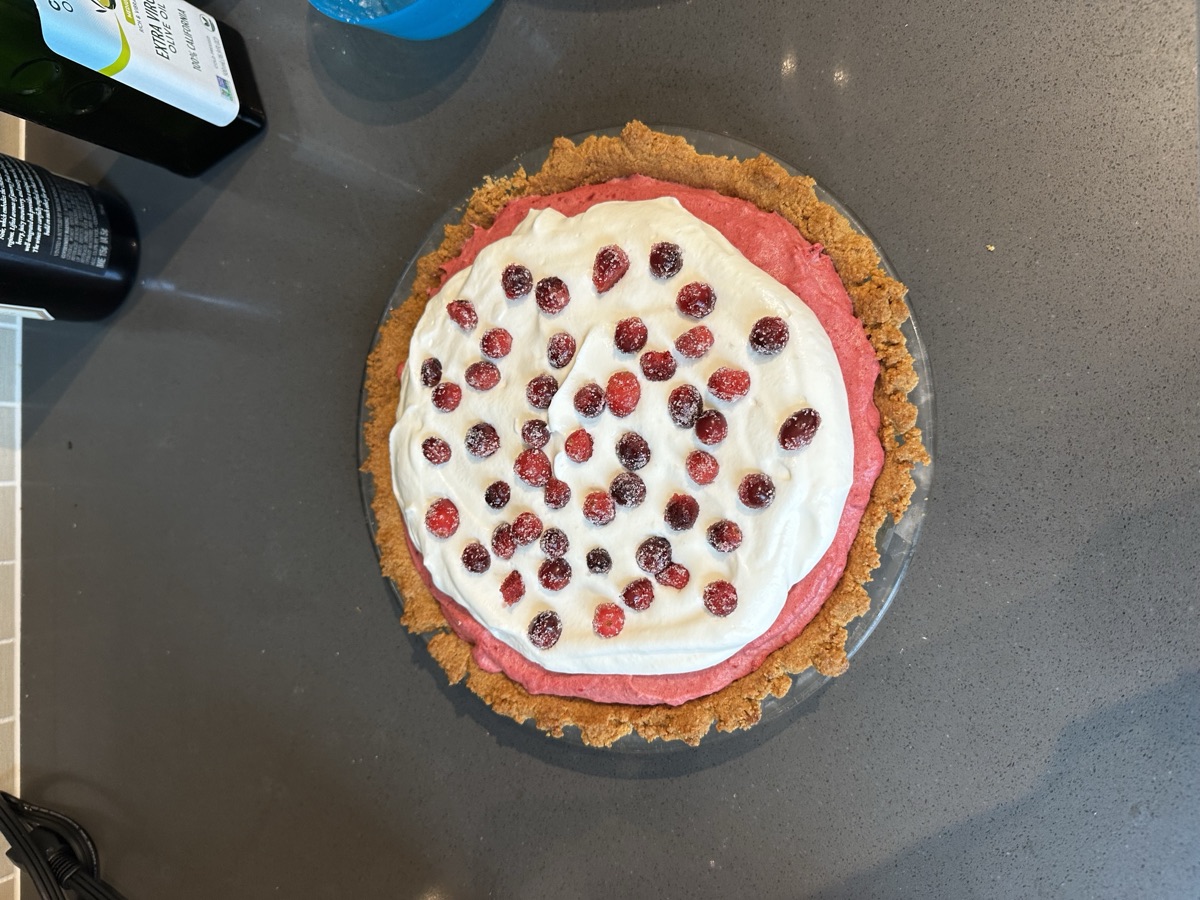 Cranberry-pomegranate mousse pie with a pink filling and sugared cranberry topping