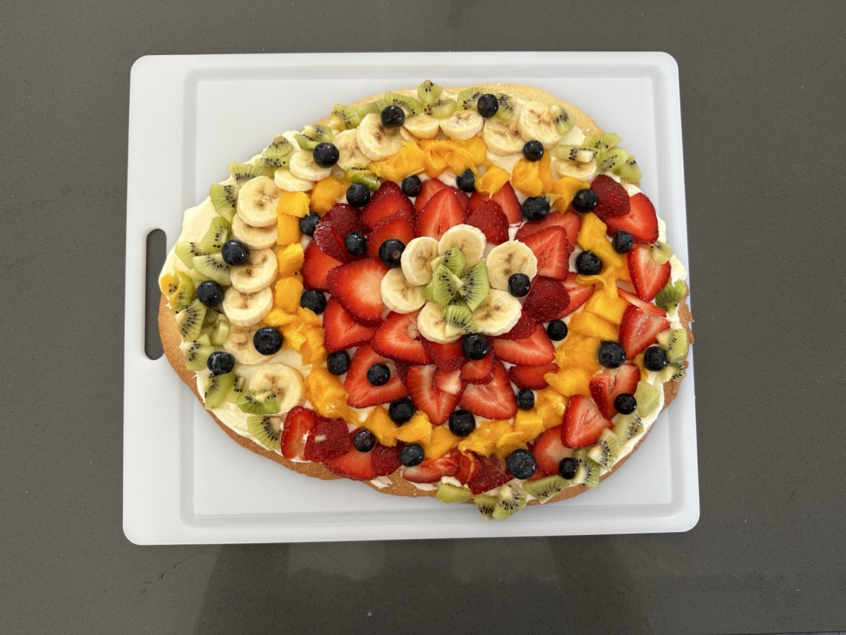 Fruit pizza decorated with colorful sliced fruit