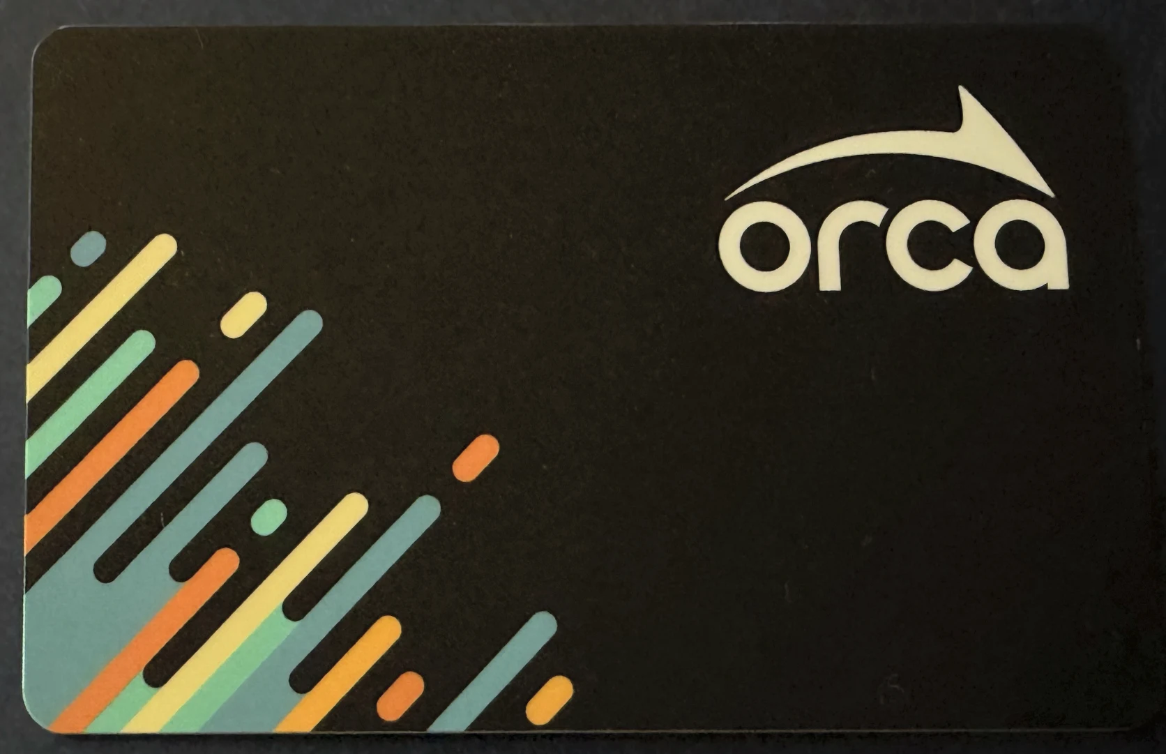 Black ORCA transit card with colorful diagonal stripes
