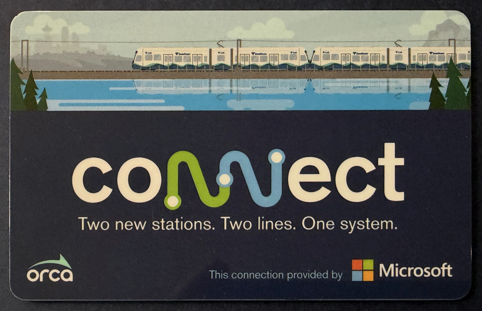Dark blue ORCA Connect transit card illustrated with Link light rail trains