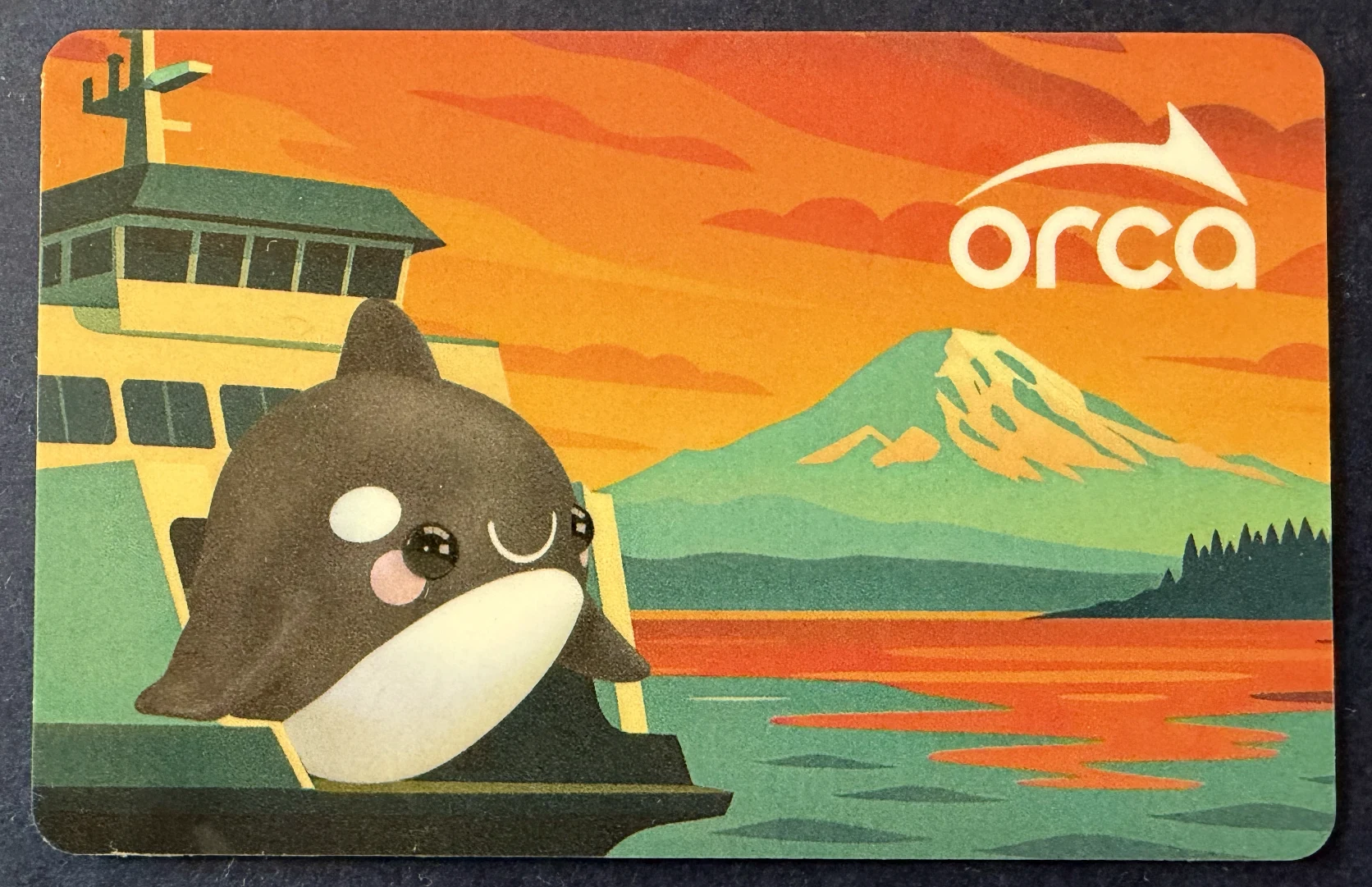 Orange ORCA transit card illustrated with an orca on a ferry and Mount Rainier